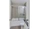 Bathroom features a tiled shower with glass door and vanity with black countertop at 781 Ne 130Th Ter, Silver Springs, FL 34488