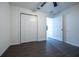Bedroom with dark laminate floors features a closet and an open doorway at 781 Ne 130Th Ter, Silver Springs, FL 34488