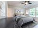 Bright bedroom with a gray bedspread and two windows at 781 Ne 130Th Ter, Silver Springs, FL 34488