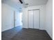 Bedroom featuring a double door closet, neutral walls, and modern gray wood-look flooring at 781 Ne 130Th Ter, Silver Springs, FL 34488