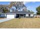 Charming single-story home with a gray exterior, stone accents, landscaped yard, and a two-car garage at 781 Ne 130Th Ter, Silver Springs, FL 34488