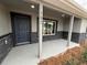 Covered front porch with gray stone accents and a dark gray front door at 781 Ne 130Th Ter, Silver Springs, FL 34488