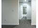 Hallway leading to a bathroom with gray wood-look floors and neutral-toned walls at 781 Ne 130Th Ter, Silver Springs, FL 34488