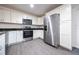 Bright and modern kitchen features stainless steel appliances, white cabinets, and stylish gray flooring at 781 Ne 130Th Ter, Silver Springs, FL 34488