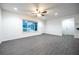 Bright living room features gray flooring, ceiling fan, recessed lighting, and a large window at 781 Ne 130Th Ter, Silver Springs, FL 34488