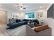 Bright living room featuring a large window, ceiling fan, and stylish blue sectional sofa at 781 Ne 130Th Ter, Silver Springs, FL 34488