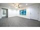 An open-concept living space with gray floors, recessed lighting, and access to a bathroom at 781 Ne 130Th Ter, Silver Springs, FL 34488