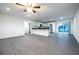 An open-concept living space with gray flooring, modern lighting, and a kitchen with stainless steel appliances at 781 Ne 130Th Ter, Silver Springs, FL 34488