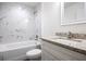 Bathroom features a white bathtub, marble-like tiling, granite vanity, and sink for a modern aesthetic at 1243 Ne 130Th Ter, Silver Springs, FL 34488