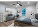 Modern bedroom with wood-look floors, a ceiling fan, a large window, and industrial-chic furnishings at 1243 Ne 130Th Ter, Silver Springs, FL 34488