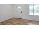 Bright entryway with wood-look flooring, white walls, white trim, and a decorative door with windows and black hardware at 1243 Ne 130Th Ter, Silver Springs, FL 34488