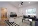 Vaulted ceiling and a ceiling fan are featured in this living room with large windows at 1243 Ne 130Th Ter, Silver Springs, FL 34488