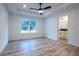 Bright bedroom with wood-look floors, ceiling fan, and en-suite bathroom access at 13050 Ne 7Th Loop, Silver Springs, FL 34488