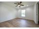 A well-lit bedroom with a ceiling fan, a large window, and beautiful wood floors at 13050 Ne 7Th Loop, Silver Springs, FL 34488