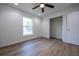Bedroom featuring new floors, a ceiling fan, closet, and a large, bright window at 13050 Ne 7Th Loop, Silver Springs, FL 34488