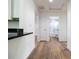 Bright hallway with wood floors leads to a bathroom and features a black countertop in view at 13050 Ne 7Th Loop, Silver Springs, FL 34488