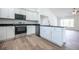 Open kitchen with stainless steel appliances, granite countertops and wood flooring at 13050 Ne 7Th Loop, Silver Springs, FL 34488