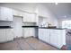 Modern kitchen featuring white cabinetry, sleek black countertops, modern faucet, and an open layout for cooking and entertaining at 13050 Ne 7Th Loop, Silver Springs, FL 34488