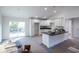 Bright kitchen with white cabinets, black countertops, an island, and sliding glass door, offering a modern and functional space at 13050 Ne 7Th Loop, Silver Springs, FL 34488