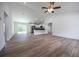 Open concept living area featuring wood-look floors, vaulted ceiling and a view into the kitchen at 13050 Ne 7Th Loop, Silver Springs, FL 34488