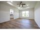 A roomy main bedroom with a tray ceiling, a ceiling fan, and a window to the outdoors at 13050 Ne 7Th Loop, Silver Springs, FL 34488