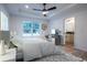 Serene main bedroom featuring a tray ceiling, ceiling fan, and an adjacent bathroom at 13050 Ne 7Th Loop, Silver Springs, FL 34488