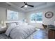 Bright main bedroom featuring a tray ceiling, ceiling fan, and a large window at 13050 Ne 7Th Loop, Silver Springs, FL 34488