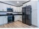 Modern kitchen with white cabinets, black appliances, and granite countertops at 600 Ne 130Th Ter, Silver Springs, FL 34488