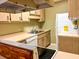 View of kitchen with wood cabinets, white appliances, and a large sink at 10730 Se 50Th Ave, Belleview, FL 34420