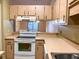 Kitchen with wood cabinets, white appliances and view to the back at 10730 Se 50Th Ave, Belleview, FL 34420