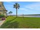 Lush grassy backyard with tropical palm trees and a serene river view at 14 Ocean Palm Villa S # 14, Flagler Beach, FL 32136