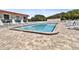 Community pool with a brick paver deck area and poolside furniture at 14 Ocean Palm Villa S # 14, Flagler Beach, FL 32136
