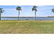 Riverfront view of the grassy lawn and tropical trees at 14 Ocean Palm Villa S # 14, Flagler Beach, FL 32136