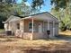 Tan house with a covered porch, new construction, and landscaping at 930 Nw 6Th Terrace Ter, Ocala, FL 34475