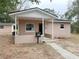 Newly constructed light brown house with a covered porch and a small yard at 930 Nw 6Th Terrace Ter, Ocala, FL 34475