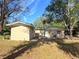 Rear view of a newly constructed light brown single-story house with shed at 930 Nw 6Th Terrace Ter, Ocala, FL 34475