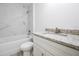 Modern bathroom featuring tub with marble-look tile surround and granite countertop at 8873 Sw 139Th Place Rd, Ocala, FL 34473