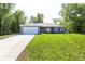 Charming single-story home featuring a two-car garage and a well-manicured lawn, nestled among mature trees at 8873 Sw 139Th Place Rd, Ocala, FL 34473