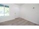 Bright living room featuring wood-look flooring and a large window for natural light, perfect for relaxation at 8873 Sw 139Th Place Rd, Ocala, FL 34473