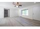 Inviting living room showcases wood-look floors, large windows, and an open layout leading to bathroom and other spaces at 8873 Sw 139Th Place Rd, Ocala, FL 34473