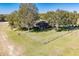 Aerial view showing home's backyard, fenced yard, and surrounding trees at 16385 Nw 112Th Ct, Reddick, FL 32686