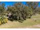 Aerial view of home nestled amongst mature trees and expansive lawn at 16385 Nw 112Th Ct, Reddick, FL 32686