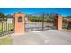 Ornate iron gate entrance to Long Pond Plantation with brick pillars at 16385 Nw 112Th Ct, Reddick, FL 32686