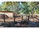 Animal enclosure with black metal gate and wooden shelter at 5919 Sw 124Th Terrace Rd, Ocala, FL 34481