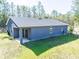 Gray house exterior with backyard and partial view of wooded area at 5919 Sw 124Th Terrace Rd, Ocala, FL 34481