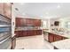 Modern kitchen with dark wood cabinets, granite counters, and stainless steel appliances at 8731 Sw 76Th Street Rd, Ocala, FL 34481