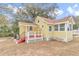 Yellow house with red steps, white accents, and a backyard at 2605 W Silver Springs Blvd, Ocala, FL 34475