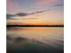 Stunning sunset over calm lake water with tree line in the distance at 11001 Se Sunset Harbor Rd # B09, Summerfield, FL 34491