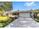 House exterior featuring a light green facade, attached garage, and a well-maintained lawn at 11436 Sw 84Th Court Rd, Ocala, FL 34481