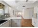 Kitchen with white cabinets, tile backsplash, and view into living area at 11436 Sw 84Th Court Rd, Ocala, FL 34481